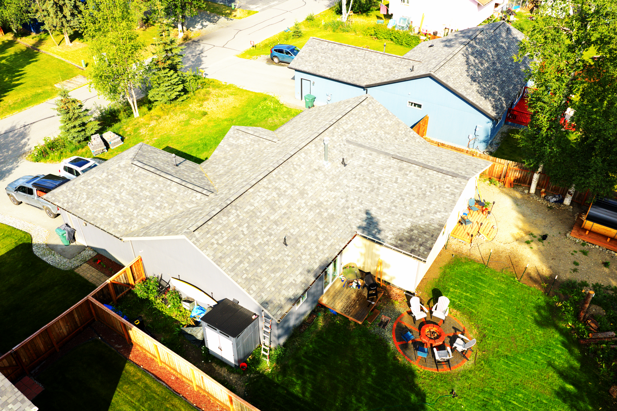 High aerial drone photo of the rear corner of an Alaska home
