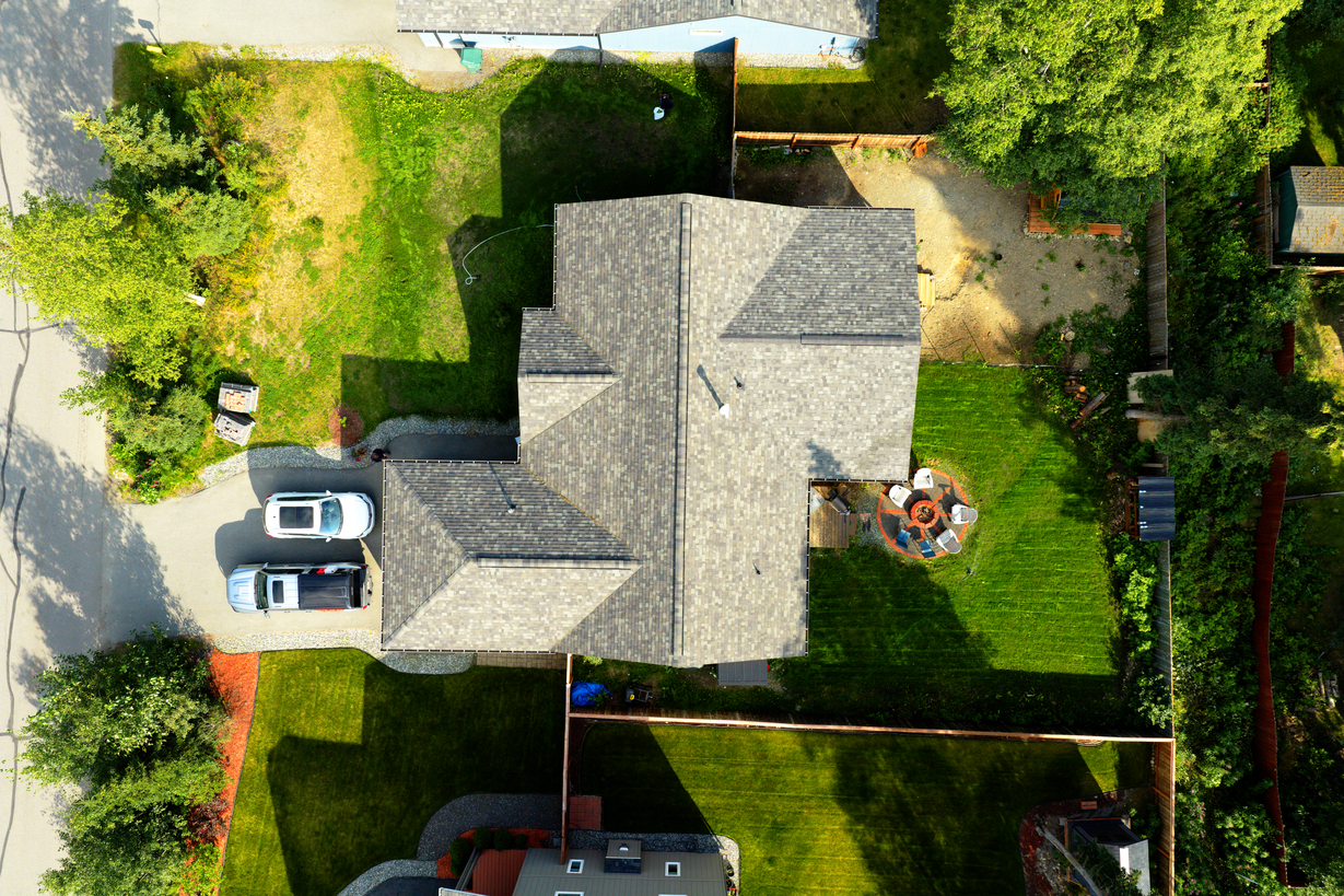 Top-down aerial drone photo showing the full lot and roofline of an Alaska home